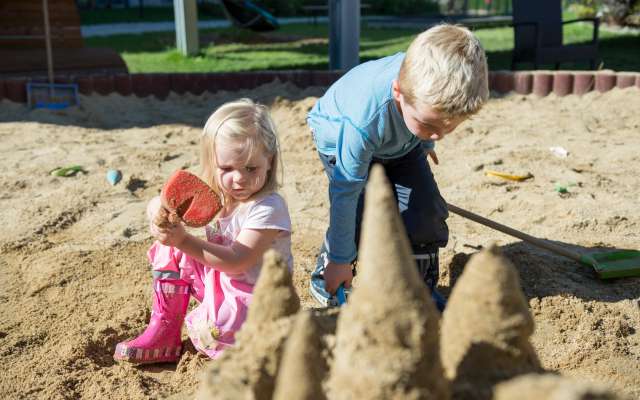 Kinder spielen im Sand auf dem Spielplatz im Familienhotel Schreinerhof