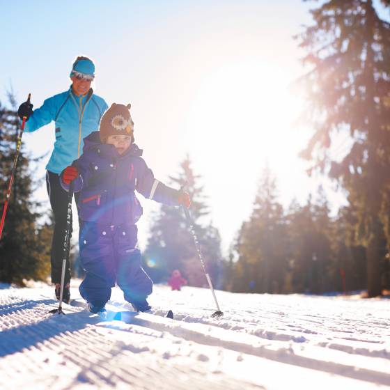 Vater mit Kind beim langlaufen im bayerischen Wald