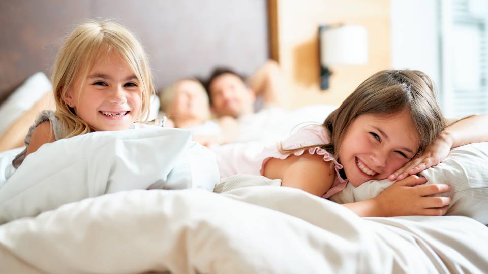 Familie im Familien Apartment im Bett im Familienhotel Schreinerhof