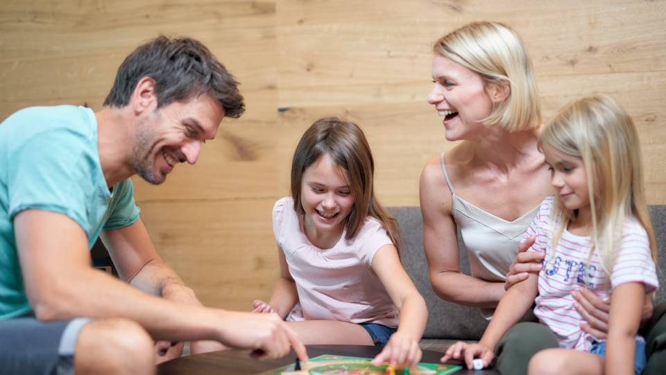 Familie im Familien Apartment spielt Brettspiel im Familienhotel Schreinerhof