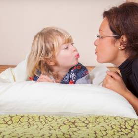 Mutter spielt mit ihrem Kind im Bett