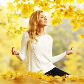Frau meditiert im Herbst