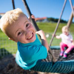 Kinder schaukeln auf unserem Spielplatz