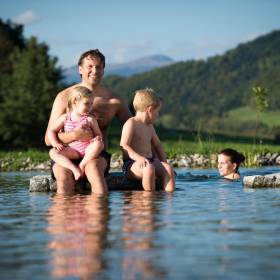 Vater mit seinen Kindern am Natur- und Erholungssee im Familienhotel Schreinerhof