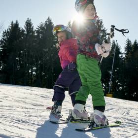 Kinder lernen das Skifahren im bayerischen Wald