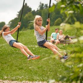 Kinder schaukeln auf unserem Spielplatz