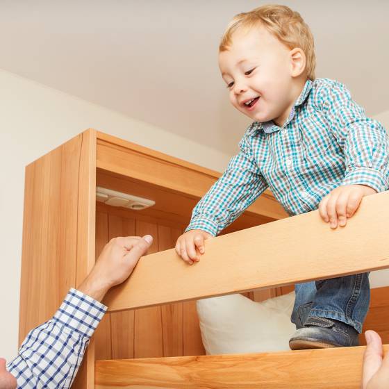 Kind schaut aus Hochbett herab