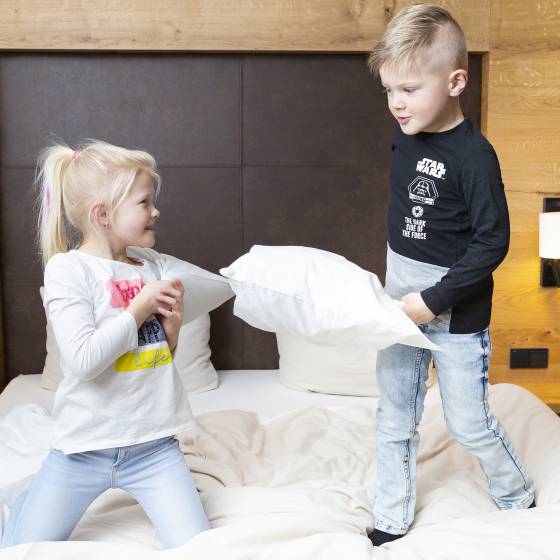 Kinder springen im Bett im Familienhotel Schreinerhof