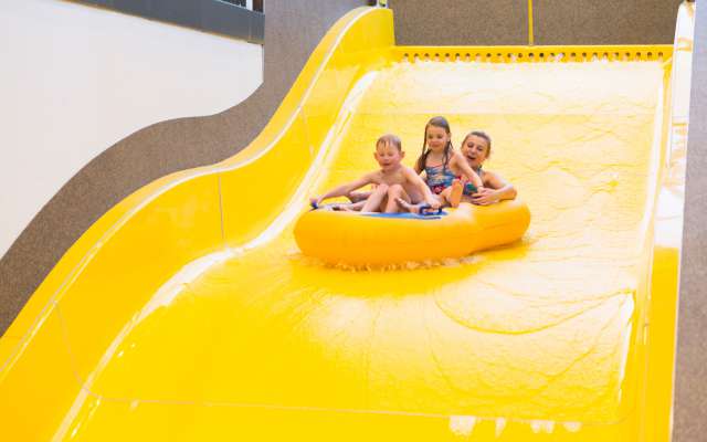 Kinder rutschen auf Botts-Wasserrutsche im Familienhotel Schreinerhof