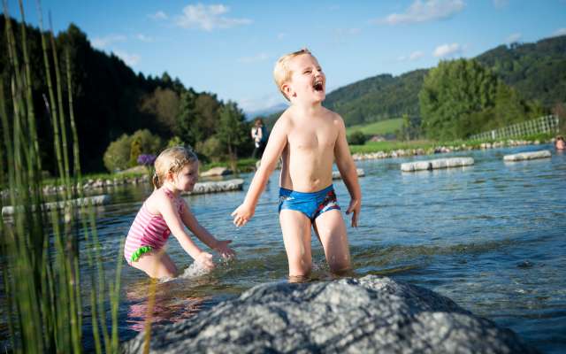 Kinder plantschen im Naturbadeteich im Familienhotel Schreinerhof