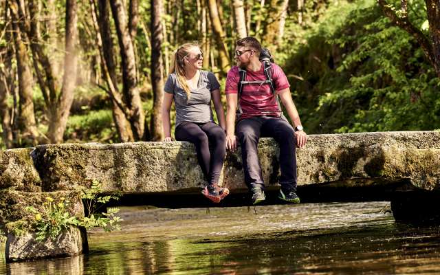 Pärchen mach Pause und genießt das Wandern am Bach