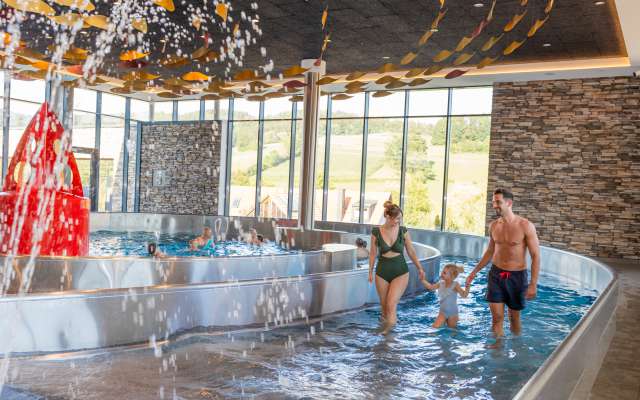 Eltern mit Kleinkind im Hotel Schwimmbad mit Wellenbad