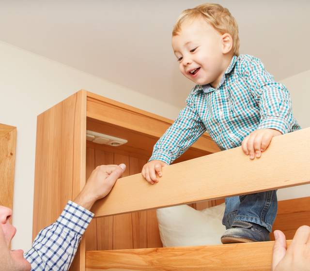 Kleiner Junge blickt auf Vater vom Hochbett