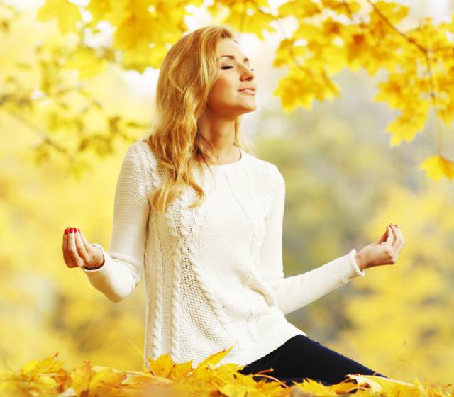 Frau meditiert im Herbst