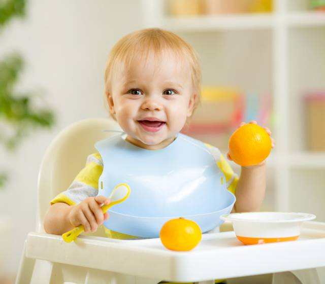 Baby spielt an Baby-Esstisch
