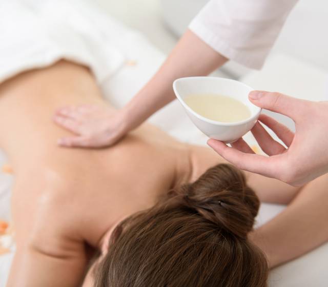 Frau erhält eine Massage-Öl-Anwendung