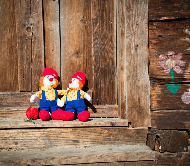 Happy Maskottchen Plüschfiguren an Holzwand