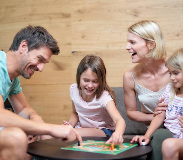 Familie im Familien Apartment spielt Brettspiel im Familienhotel Schreinerhof