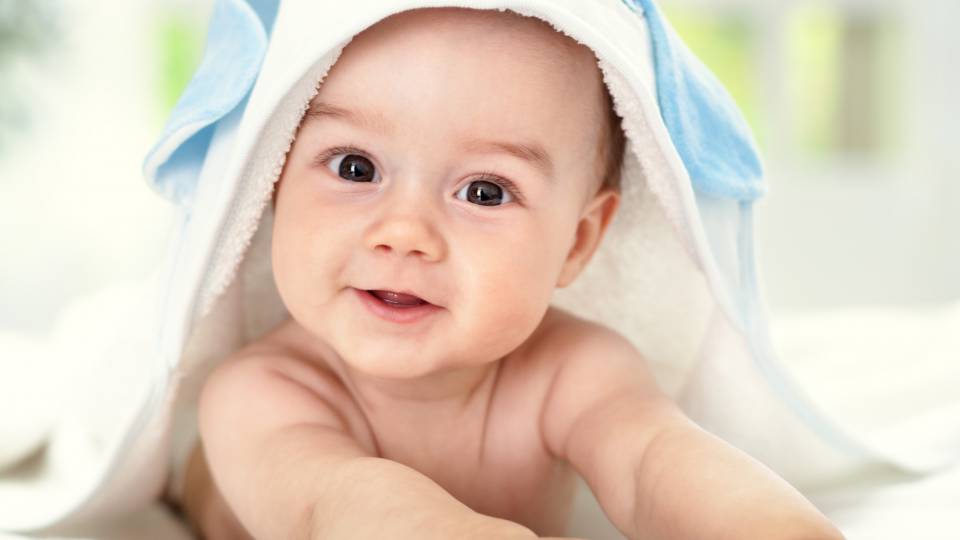 Baby blickt lächelnd in die Kamera