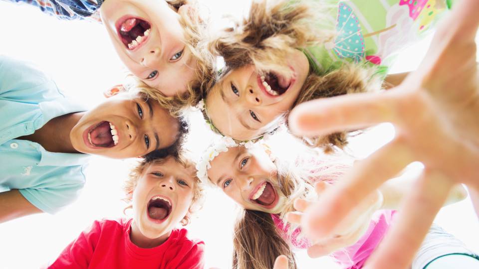 Kinder lachen in die Kamera