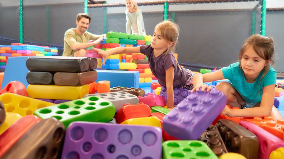 Kinder und Eltern spielen mit Riesen-Bausteinen im Familienhotel Schreinerhof