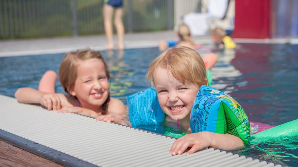 Mädchen mit Schwimmflügel im Pool